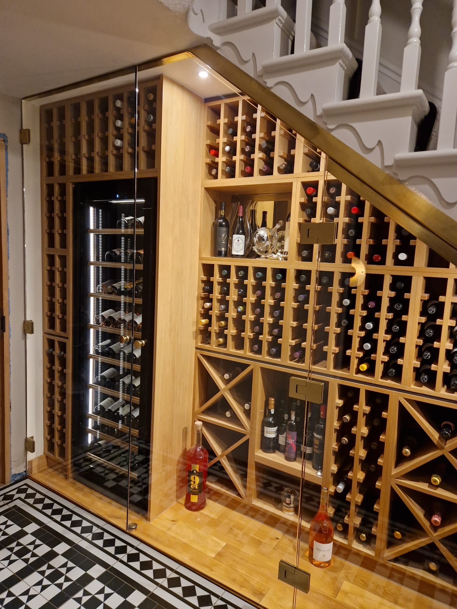 Bespoke illuminated wine storage fitted beneath a residential staircase