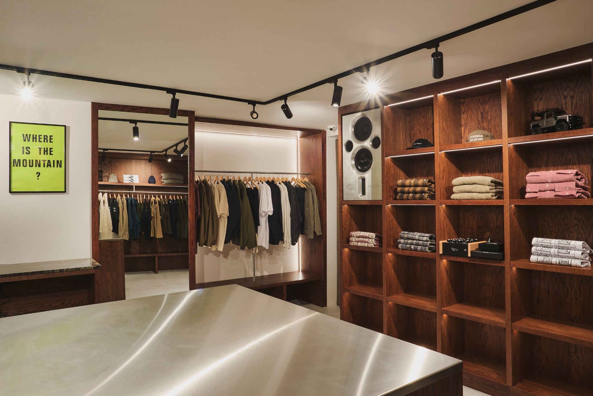 Dark timber display wall, hanging rail and stainless steel counter