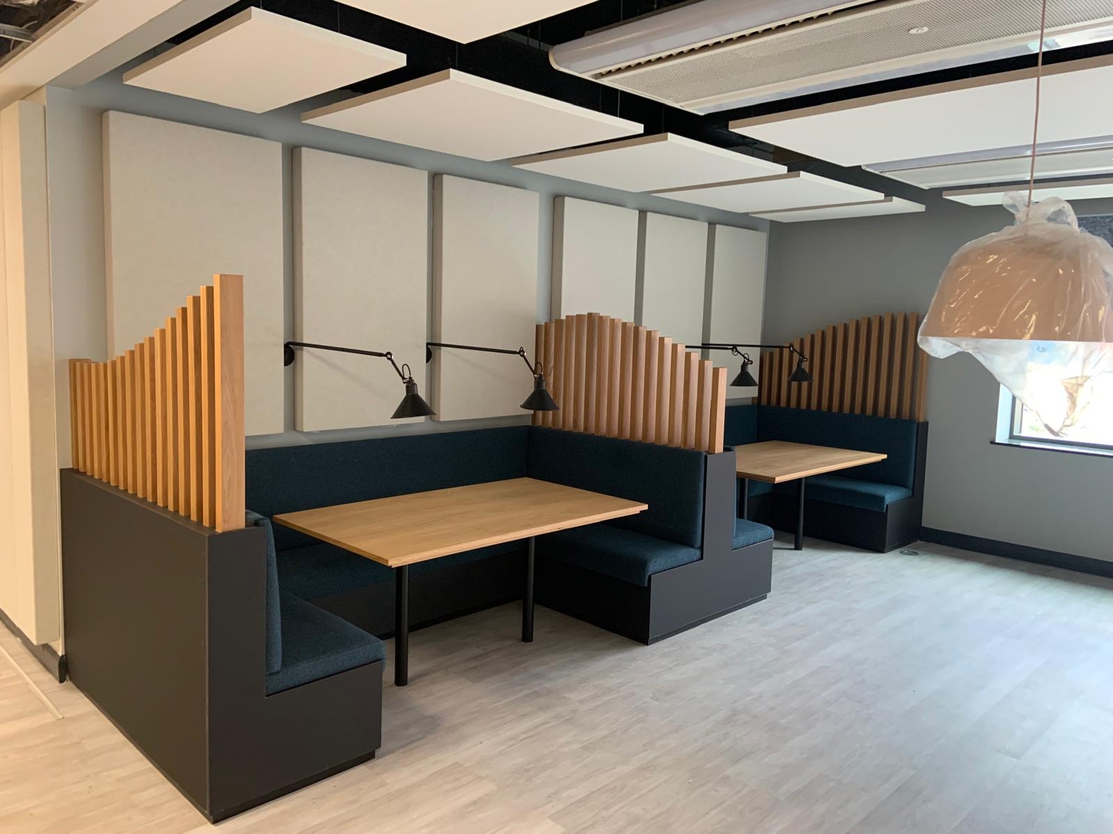 Commercial booth seating with shaped timber screening and integrated tables