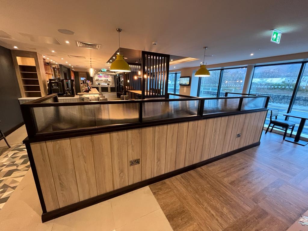 Completed hospitality interior with timber panelling and glazed screening