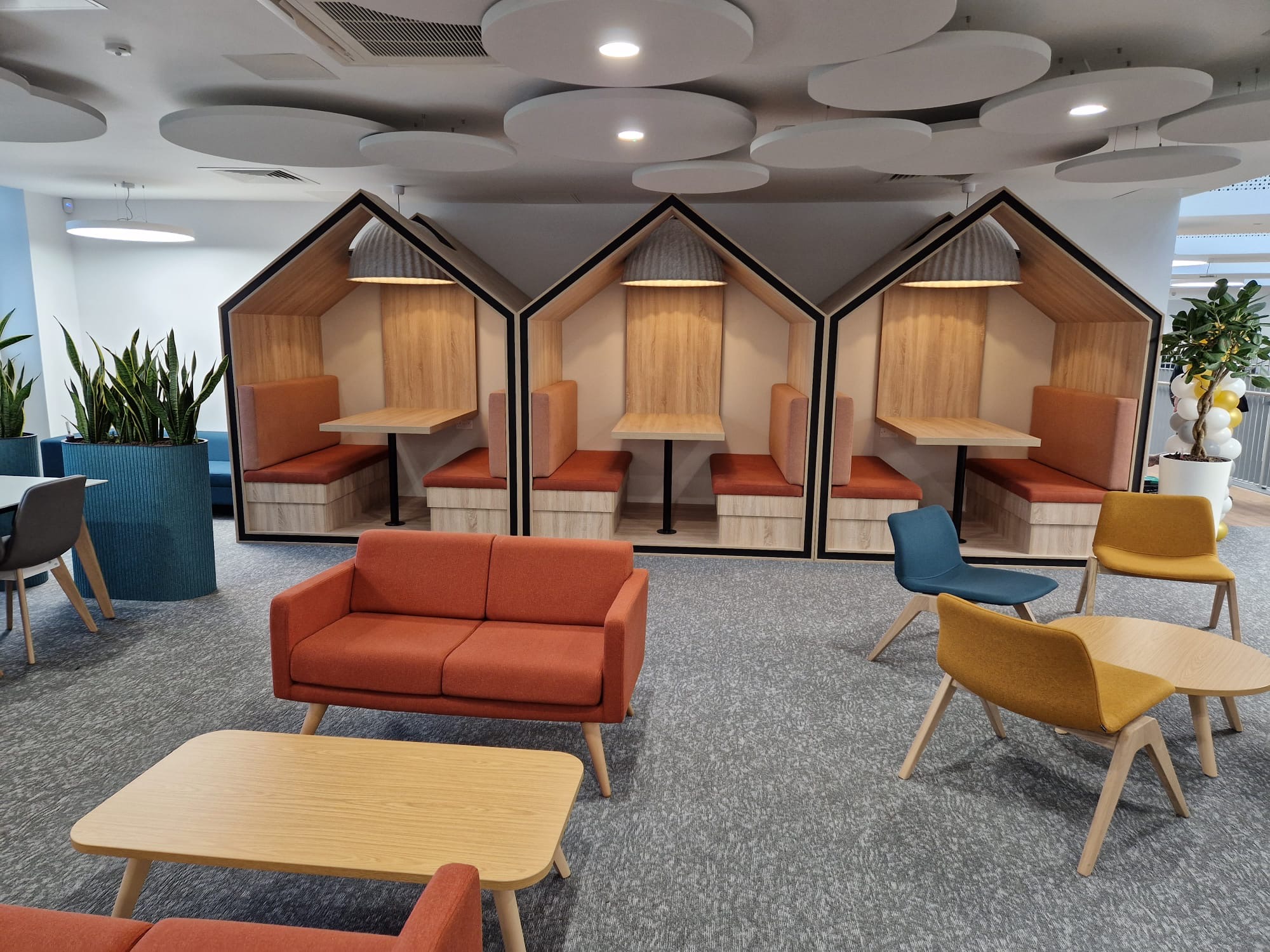 Bespoke house-shaped workplace pods with fitted seating and tables